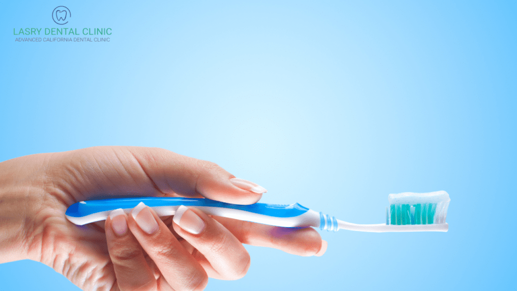 woman holding a blue toothbrush to demonstrate the best oral hygiene routine