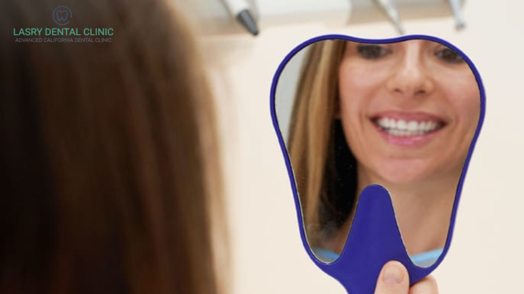 woman at the dentist holding a mirror and smiling