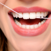 woman flossing front teeth to demonstrate how to floss your teeth properly
