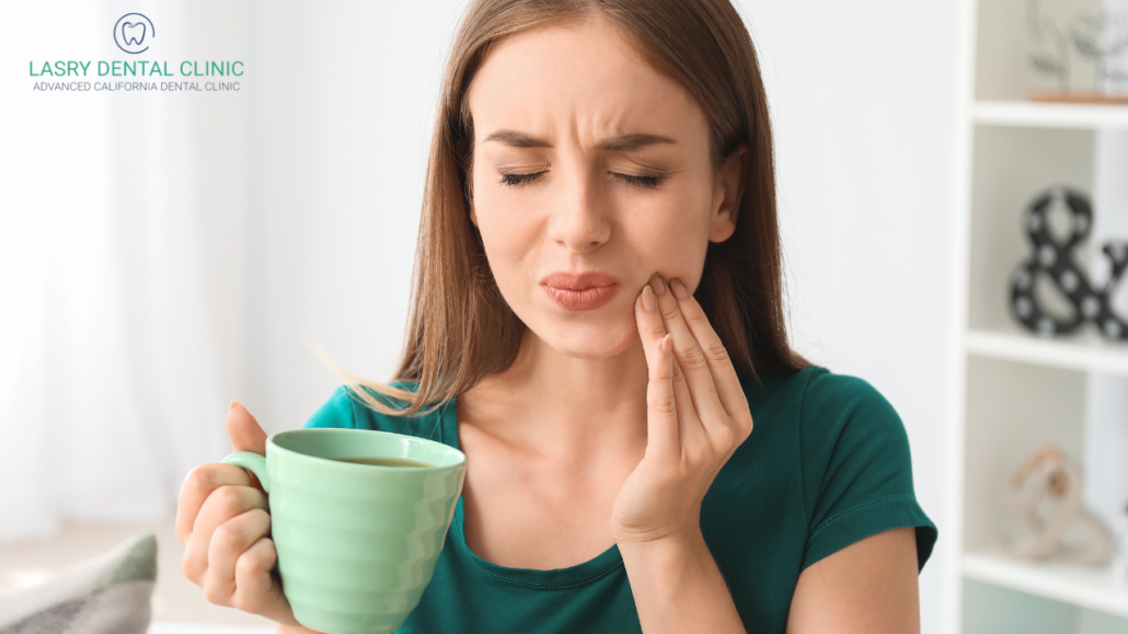 what to do about hot sensitivity - woman with teeth sensitivity holding her drink after drinking coffee